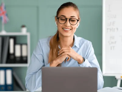 Woman with headphones participating in a video call, discussing the details of the company name change with her team.