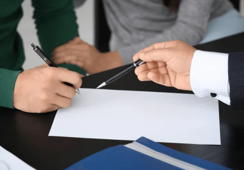 Firma de documentos clave en un proceso de reestructuración empresarial, reflejando el Cese de Administradores Online.