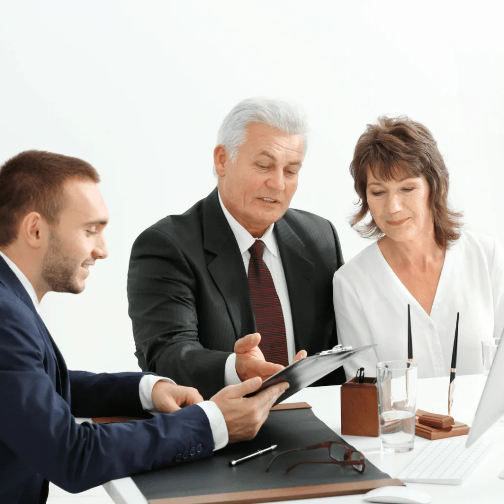 Pareja de mayores revisando un contrato con su asesor legal en una oficina moderna, asegurando la legalización de libros online.