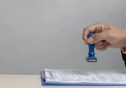 Persona certificando un documento con un sello azul.