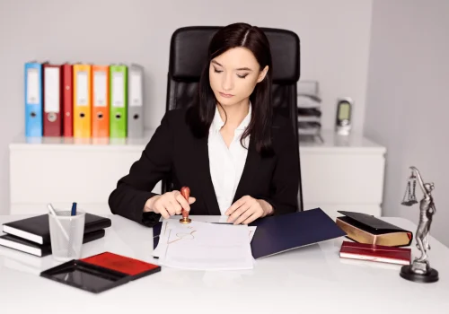 Abogado en oficina aplicando un sello oficial a documentos, representando la validación de acuerdos